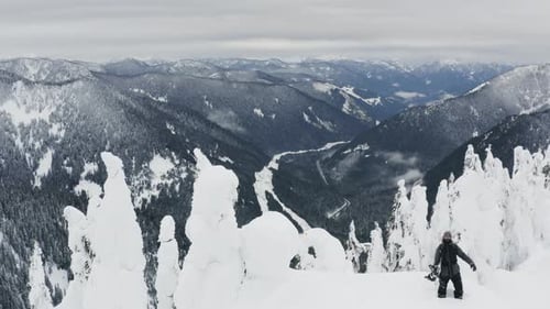 Amazing View Flying Above Snowboarding Man Standing On Mountaintop Aerial Drone Shot