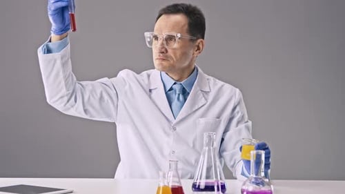 Scientist Working with Solutions in Glassware