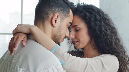 Loving Couple Embracing with Foreheads Touching in Home