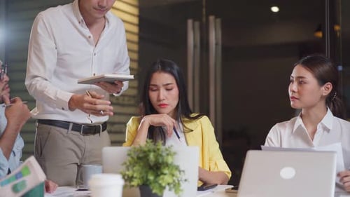 Asian young business man and woman people group have discussion meeting in office late at night.