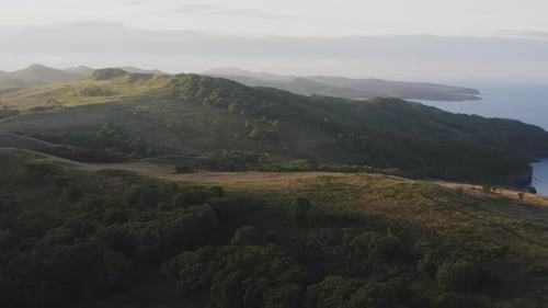 Panorama: desde un Zumbido hasta el terreno montañoso al amanecer y los barcos