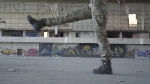 Female Legs in Military Uniform Marching on the Concrete Floor in Dusty Dirty Abandoned Building