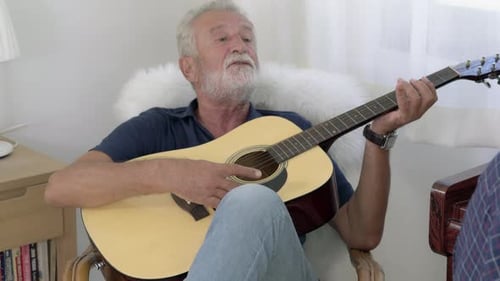 Man Playing Guitar and Singing Indoors