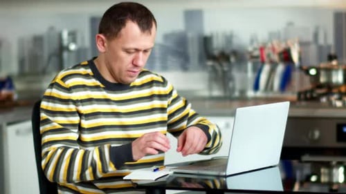 Man Working at Home Typing on Laptop