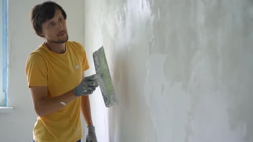 Man Plastering Wall in Interior Room
