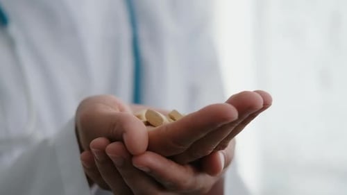Doctor Holding Pills in His Palm