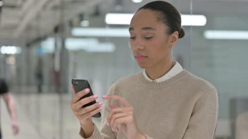 Young Woman Using Smartphone in Office Environment