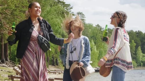 Friends Dancing with Beverages by a Lake