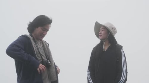 Couples of Asian tourists enjoy taking photos on top of the mountain.