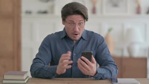 Man Reacts With Surprise While Using Phone