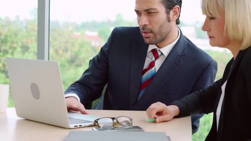 Two Business People Talk Project Strategy at Office