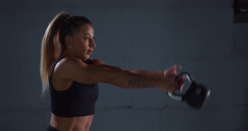 Muscular Woman Doing Exercises with Kettlebell