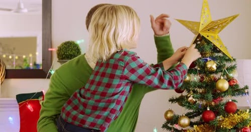 Father and Child Decorating Christmas Tree Together