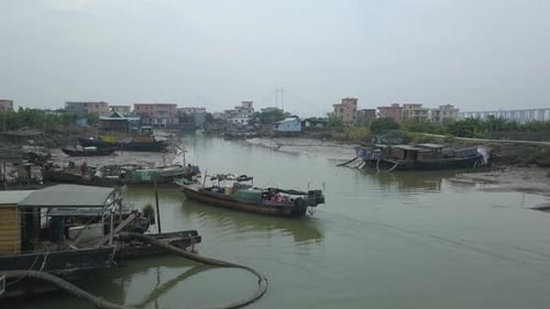 Aerial shot of a maintenance boat approaching a berth on a polluted river in Asia