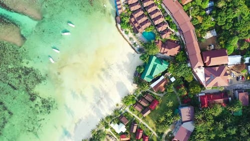 Luxurious holiday resort with bungalows and waterfront bar restaurant on white sandy beach washed by