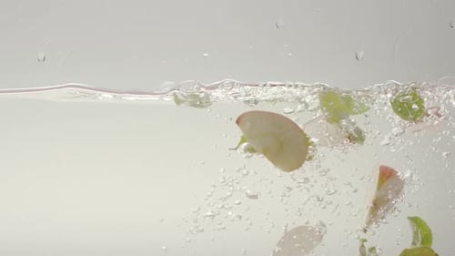 Apples and Green Leaves Submerged in Clear Water