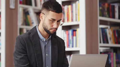 Student Using Laptop in Library for Scientific Research