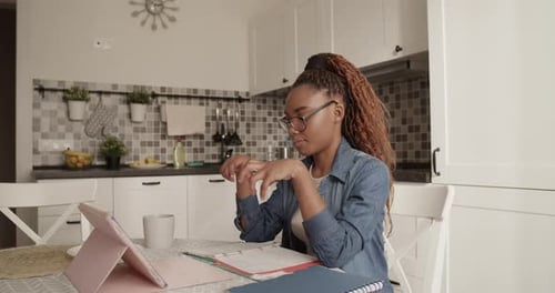Woman Talking on Tablet at Kitchen Table