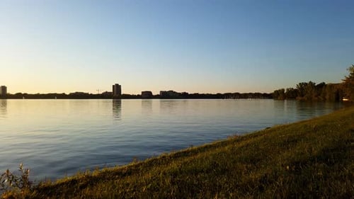 Zeitraffer bei Sonnenuntergang am See, Bewegungsraffer während der Goldenen Stunde