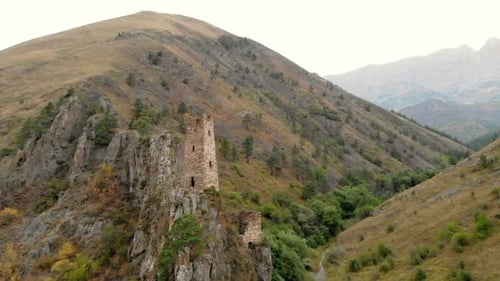 View From Quadrocopter Flying Past Mountain From an Old Stone Tower