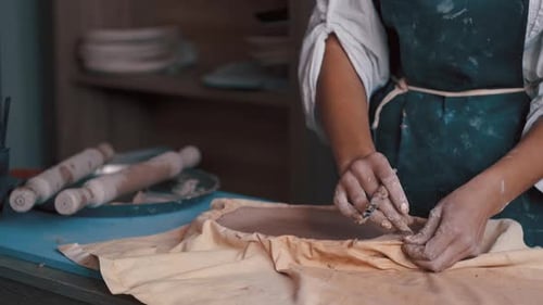 Artist Shaping Clay with Tool