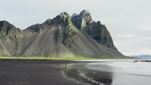 Drone Of Man On Black Beach Under Vestrahorn Mountain