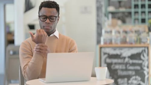 Man Works on Laptop in Coffee Shop