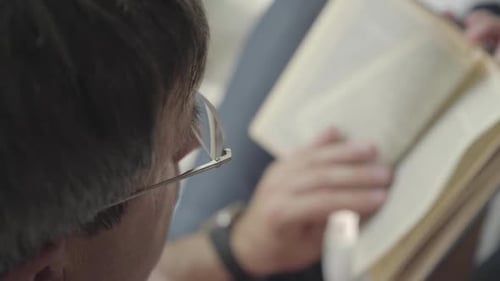 Man Reading Book Indoors Close Up