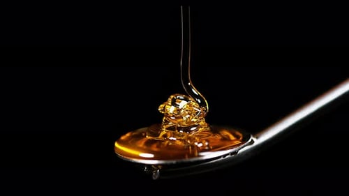 900375 Honey Flowing on Spoon against Black Background, Slow Motion 4K