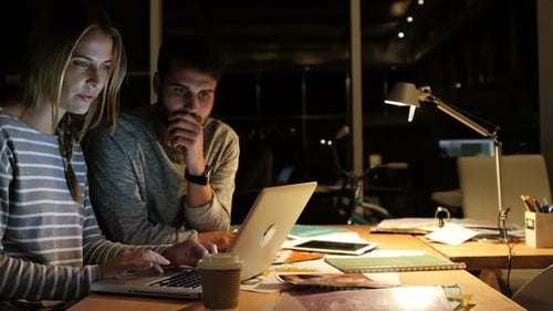 Team Working on Laptop Late at Night