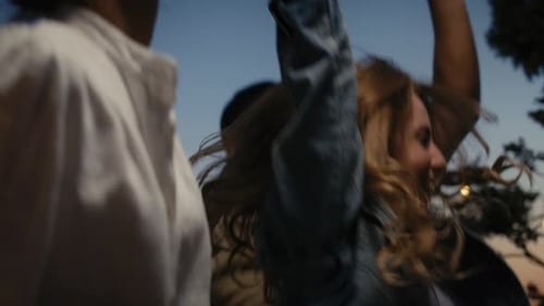 Friends Dancing Joyfully Outdoors at Dusk