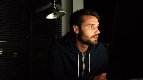Young Man Working Late at Computer at Night