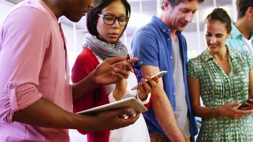 Team Gathers Around Technology in Workplace