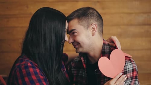 Loving Couple Embrace Holding Paper Hearts