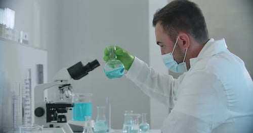 Scientist Conducting Experiment in Lab with Blue Liquid
