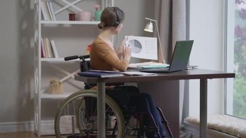 Woman in Wheelchair Works from Home at Desk