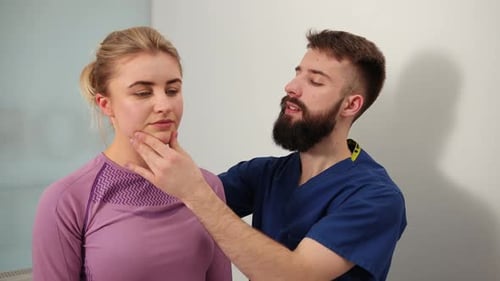 Medical Professional Examining Woman's Face and Neck