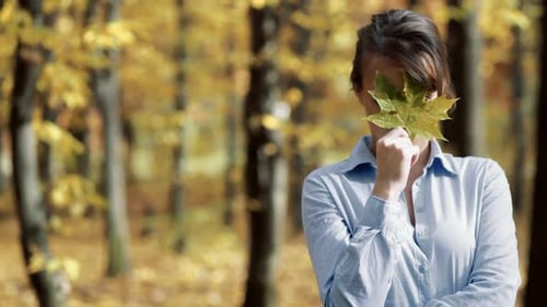 Sunny autumn day in park. Young woman spending time in autumn park