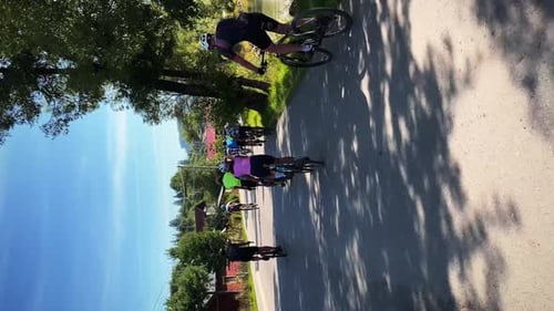 Gruppe von Radfahrern, die an sonnigen Sommertagen Fahrrad fahren. Vertikales Video