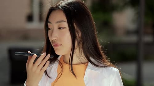 Young Woman Uses Voice Command on Smartphone