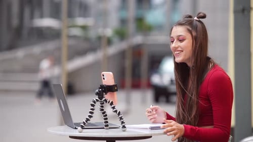 Freelance Woman in a Summer Cafe Communicating Via Video Link