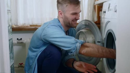 Man Taking Laundry Out of Washing Machine