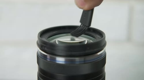 Cleaning a Black Camera Lens with Brush