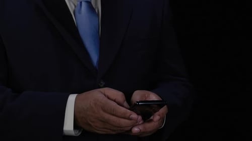Person in Suit Uses Mobile Phone