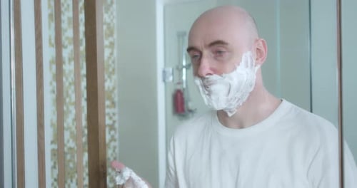 Middleaged is Shaving Using Disposable Razor in Bathroom Closeup Side View