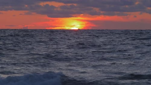 Romantic vibrant scenic red sunset over the Baltic beach at Liepaja with vibrant blue clouds, wide s