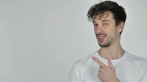 Young Casual Man Pointing on Side White Background