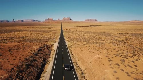 Erstaunliche Luftaufnahme eines silbernen Autos, das entlang der erstaunlichen amerikanischen Sandstone Desert Highway Road fährt
