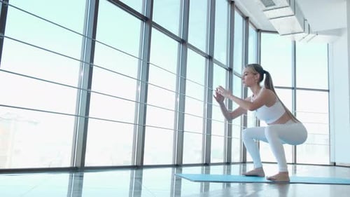 The girl performs exercises to train the legs in the gym