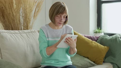 Older Woman Shopping Online with Credit Card Using Digital Tablet